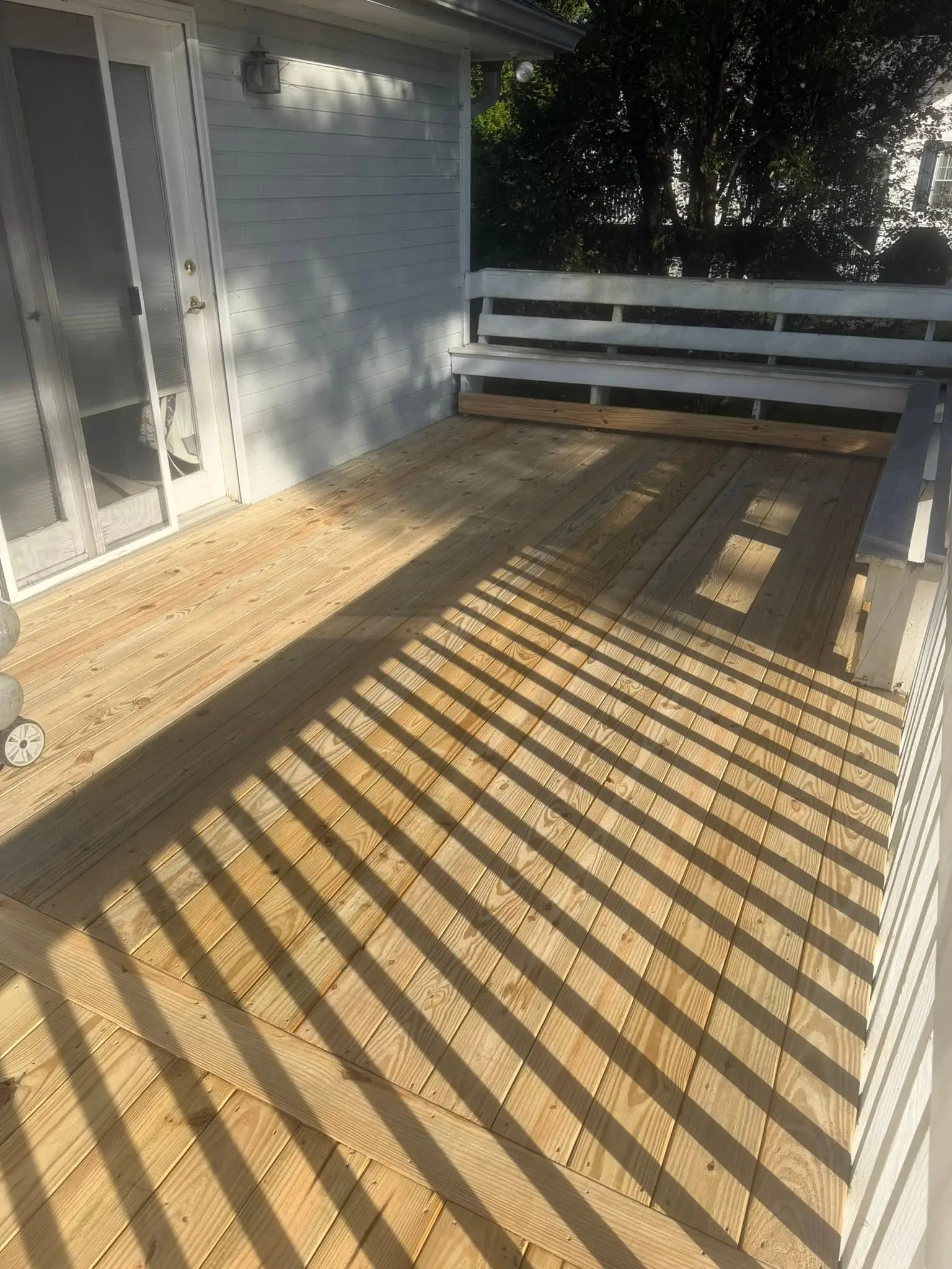 Deck floor redone with full-length boards under lattice shadow