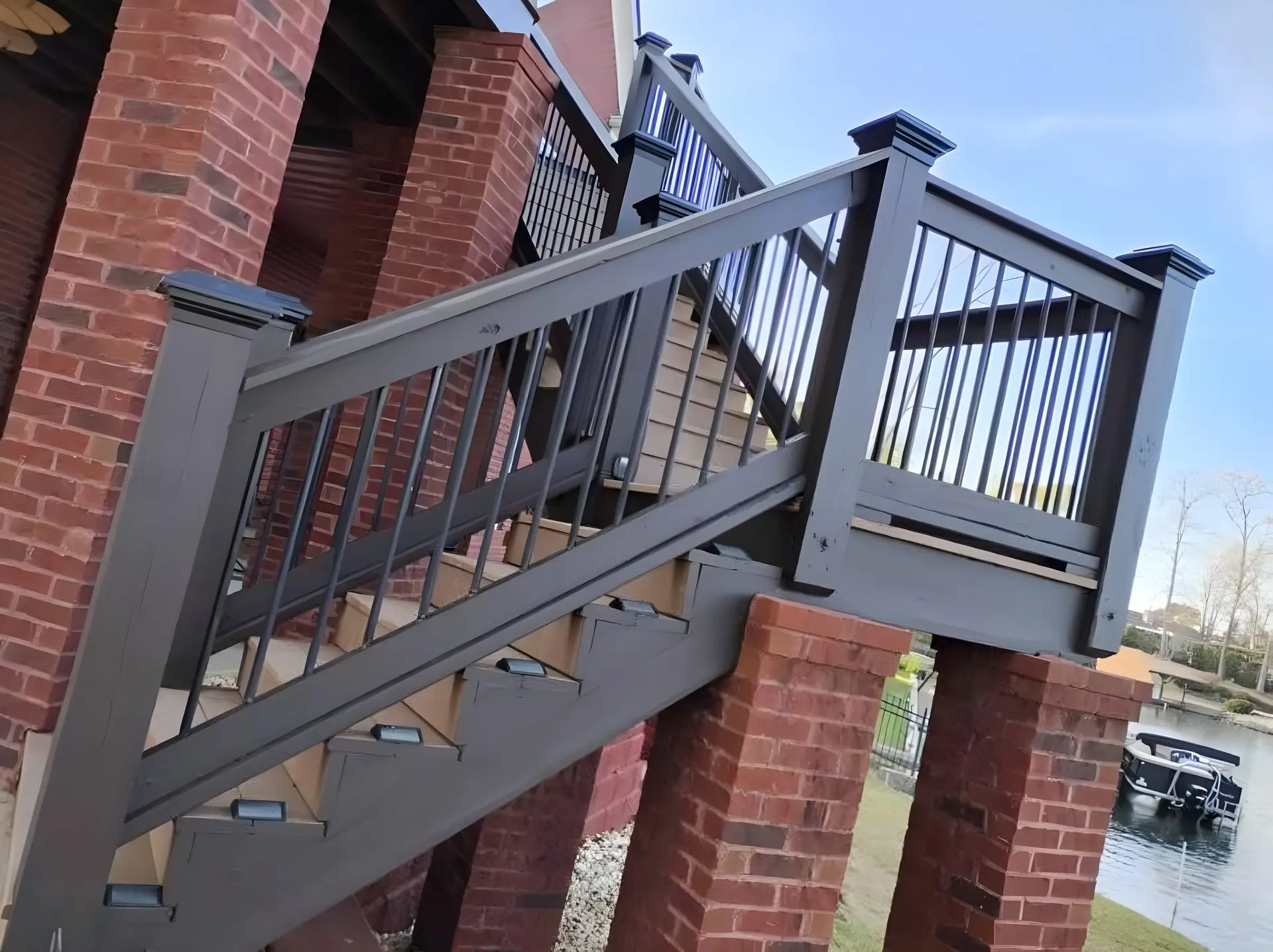 Deck stairs with black rail beside a pontoon dock