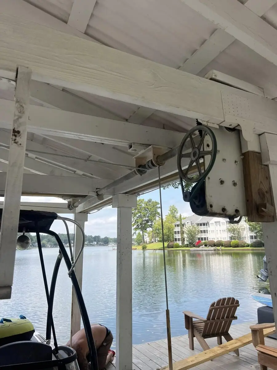 Boat lift mechanism and pulley system inside a covered boathouse overlooking the lake