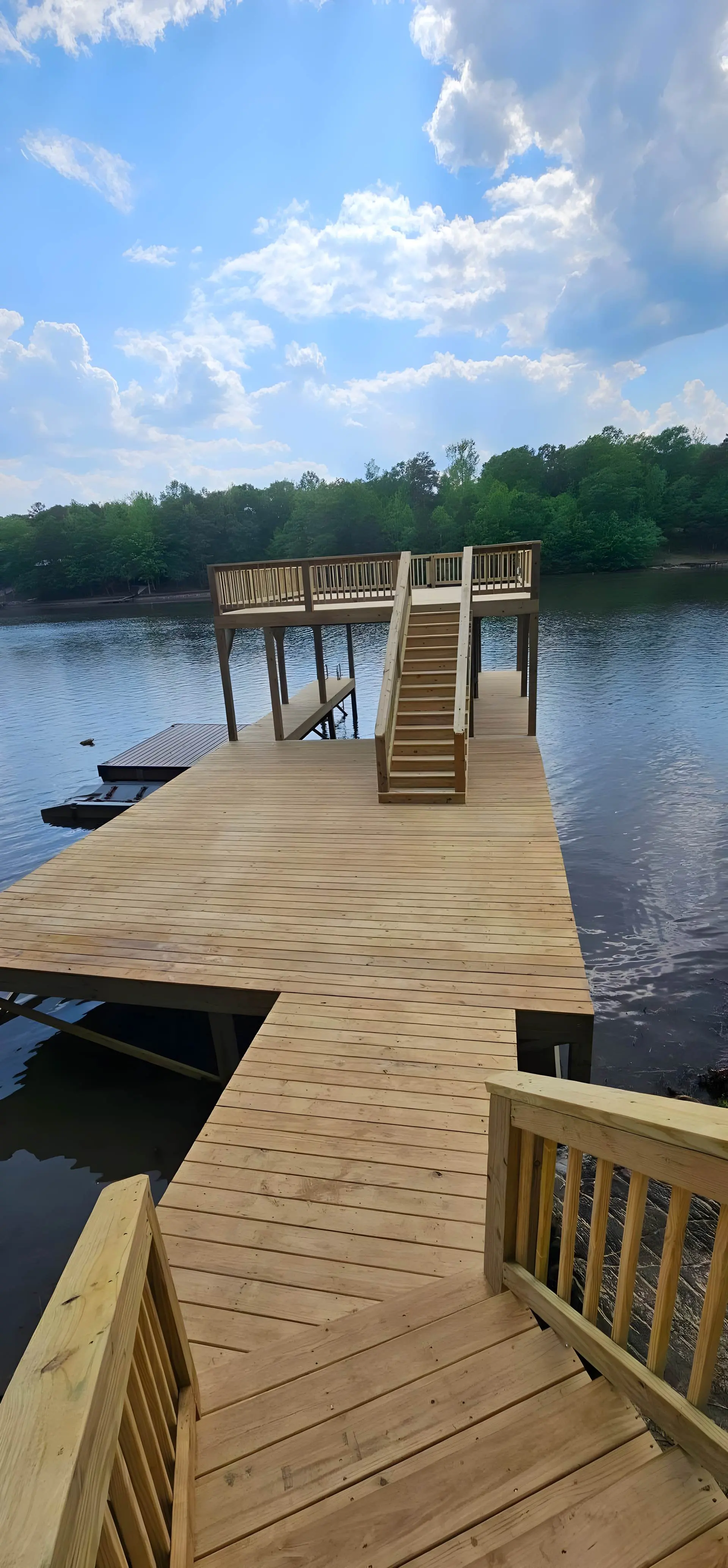 Long dock walkway leading to an elevated platform with a staircase over open lake water