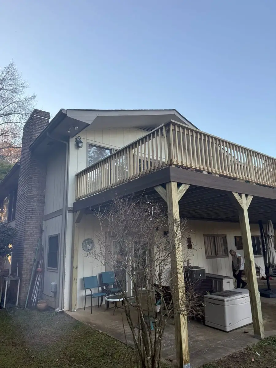 Large elevated deck rebuild with a covered patio below, worker on site
