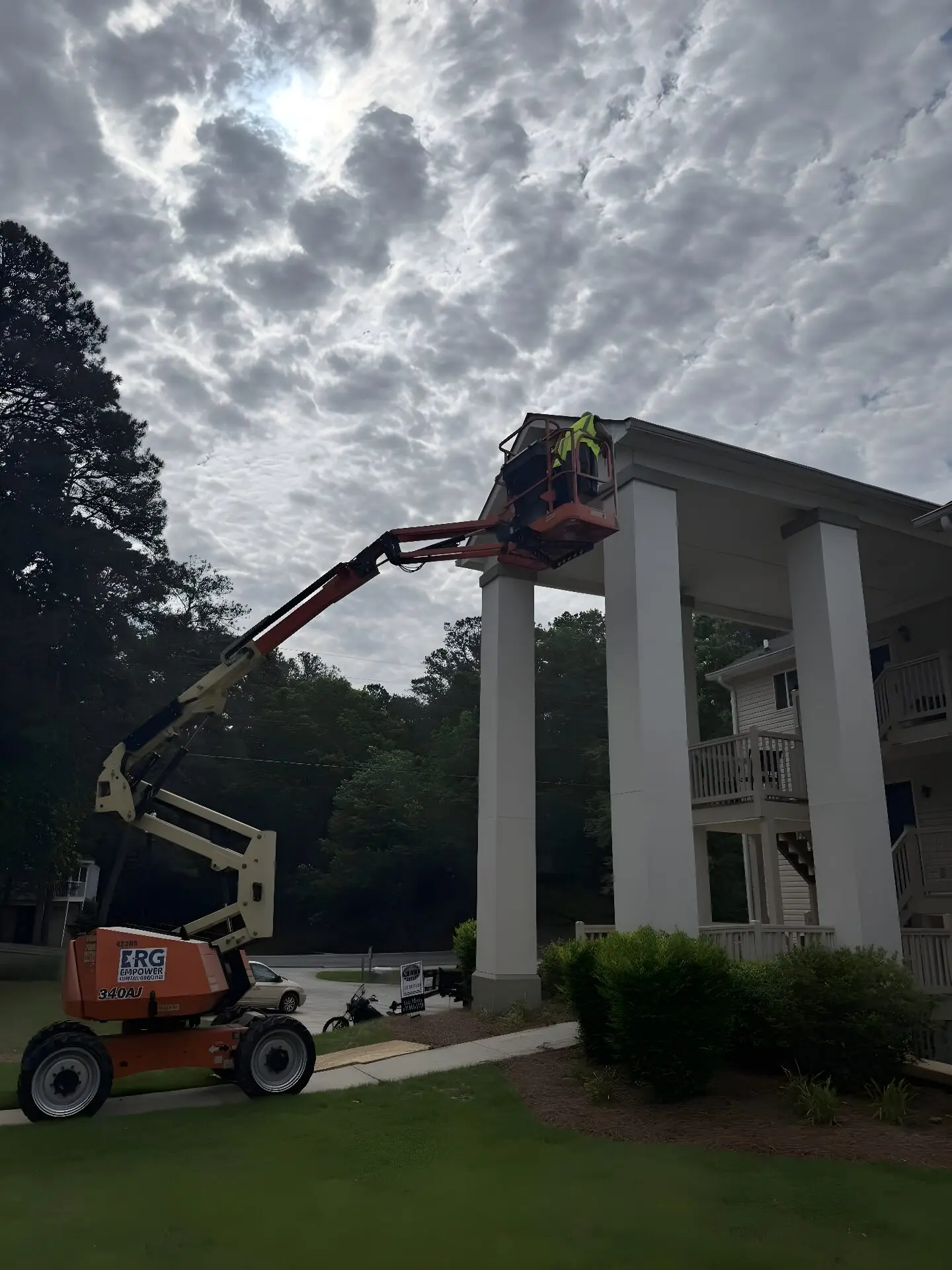Crew in an articulated boom lift painting two-story portico columns