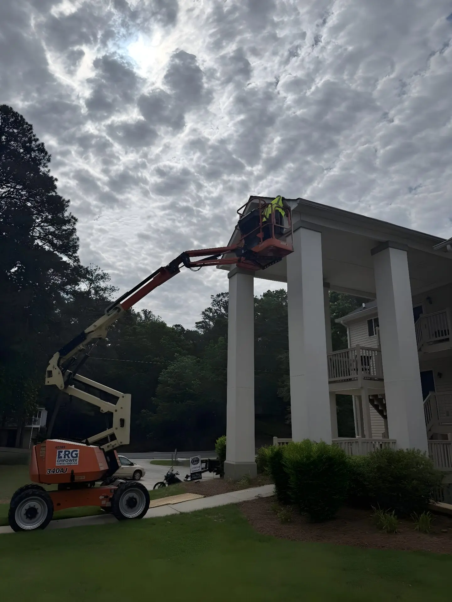 Crew in an articulated boom lift painting two-story portico columns