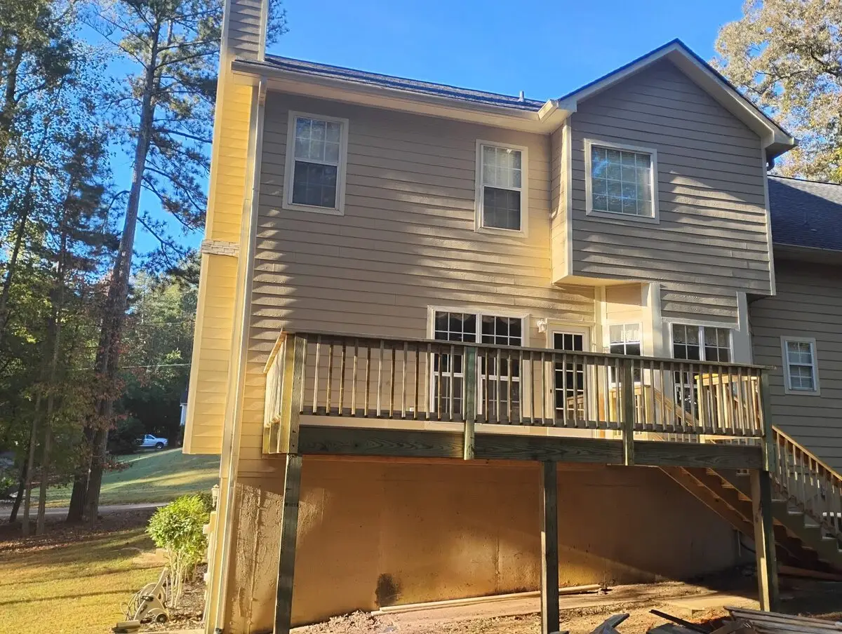 Brand-new pressure-treated deck and stairs on the back of a split-level home