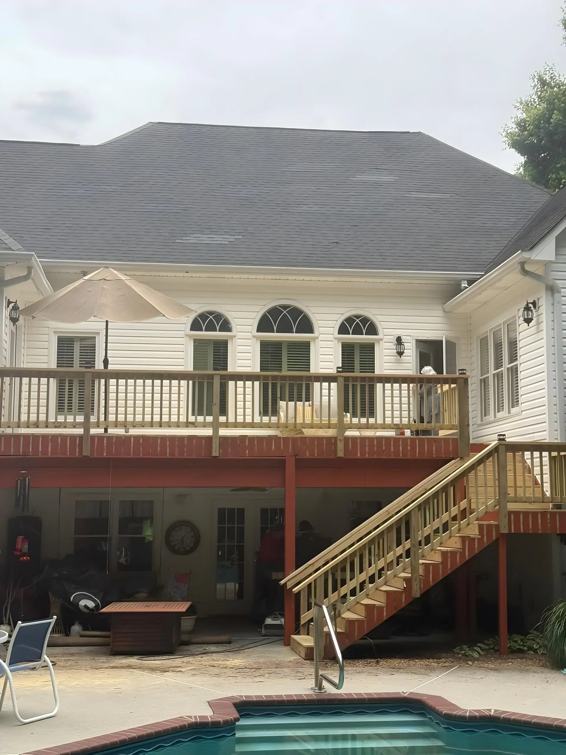 Second-story wood deck with a new staircase down to a backyard pool