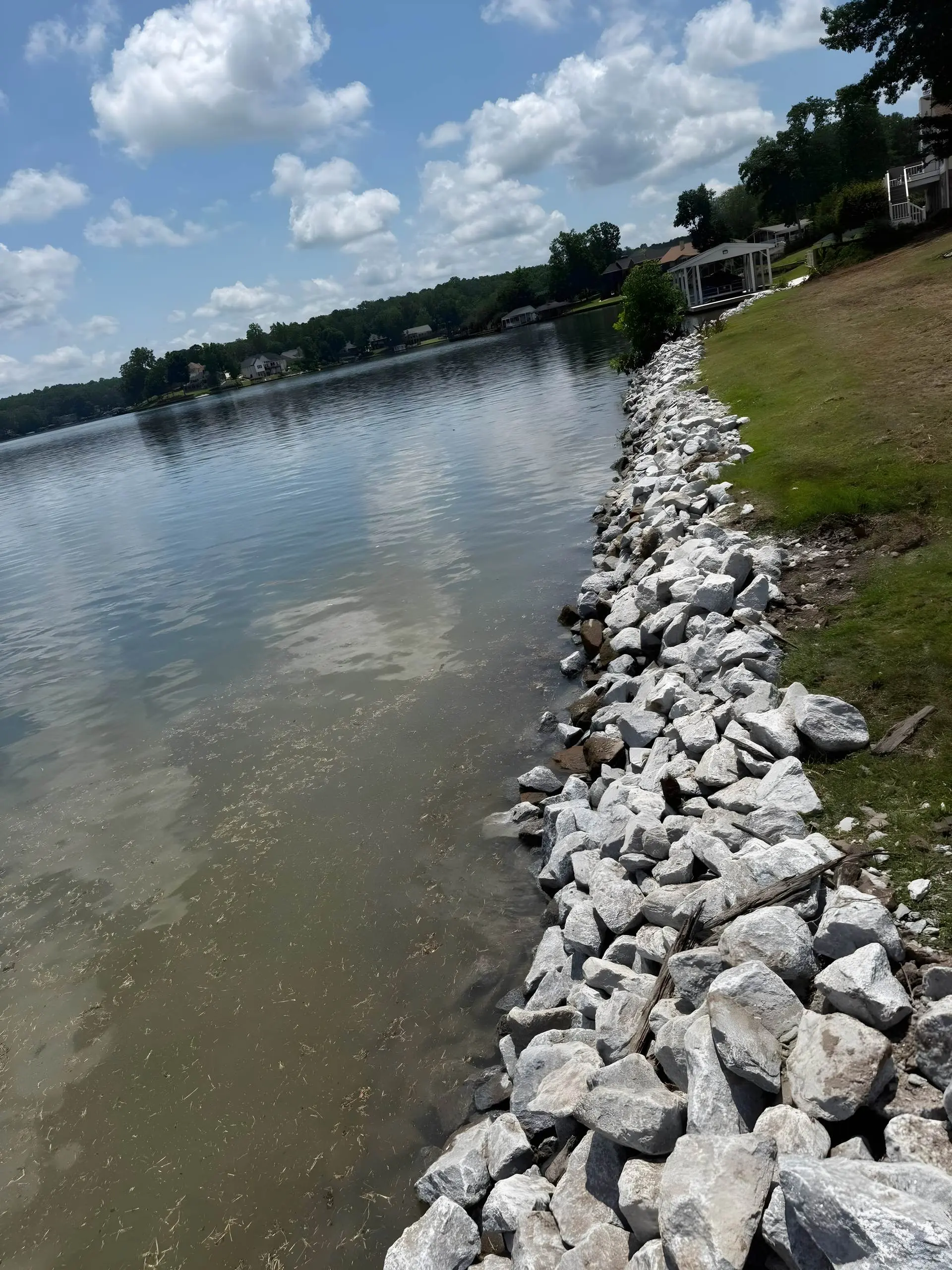 Rip-rap stone seawall running along a lake shoreline