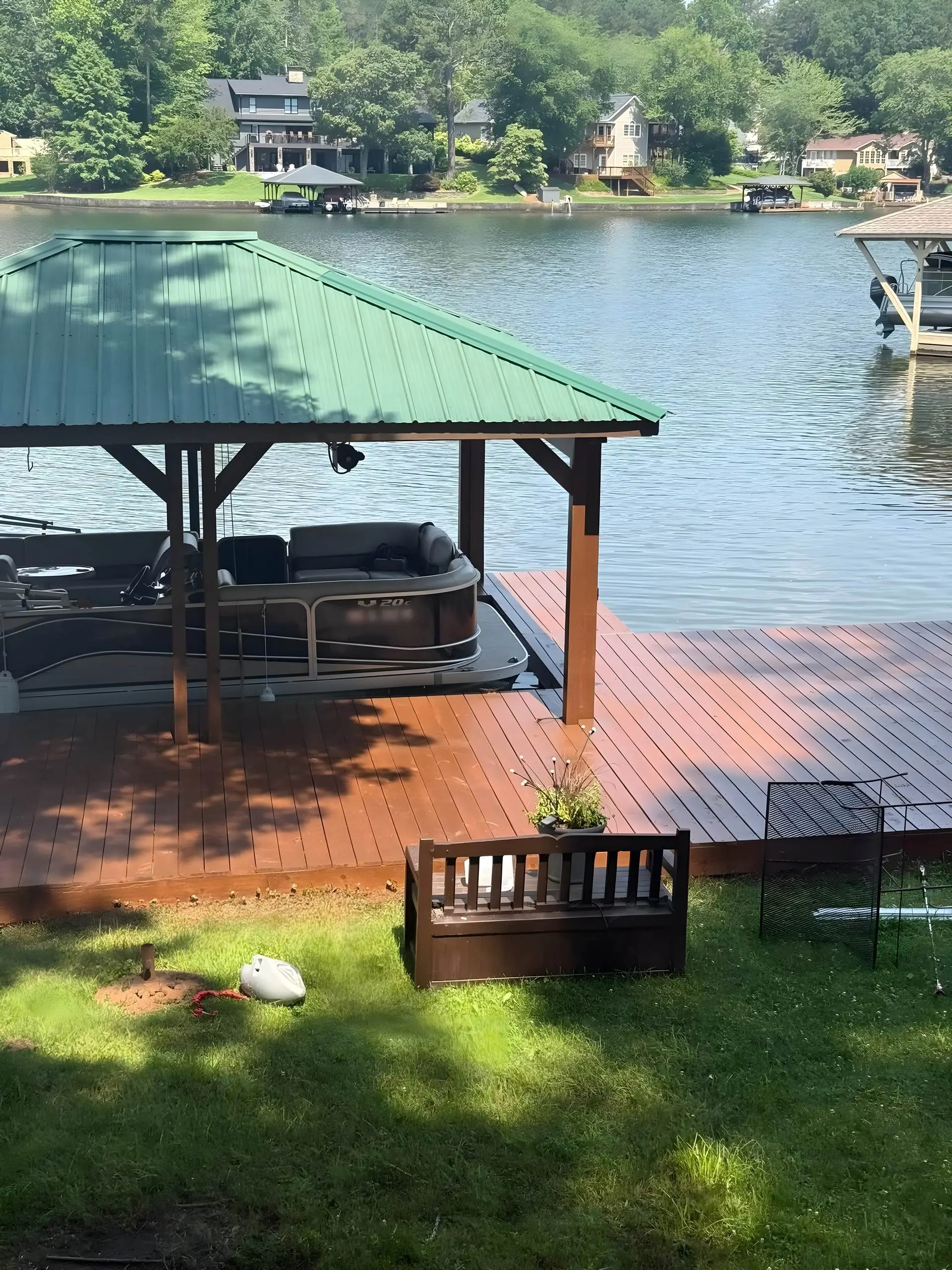 Freshly stained dock with a covered boat slip and wide lake view