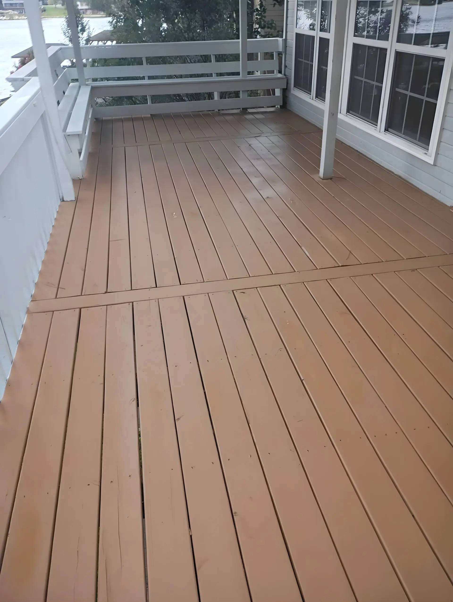 Finished stained deck with white rail and an open lake view