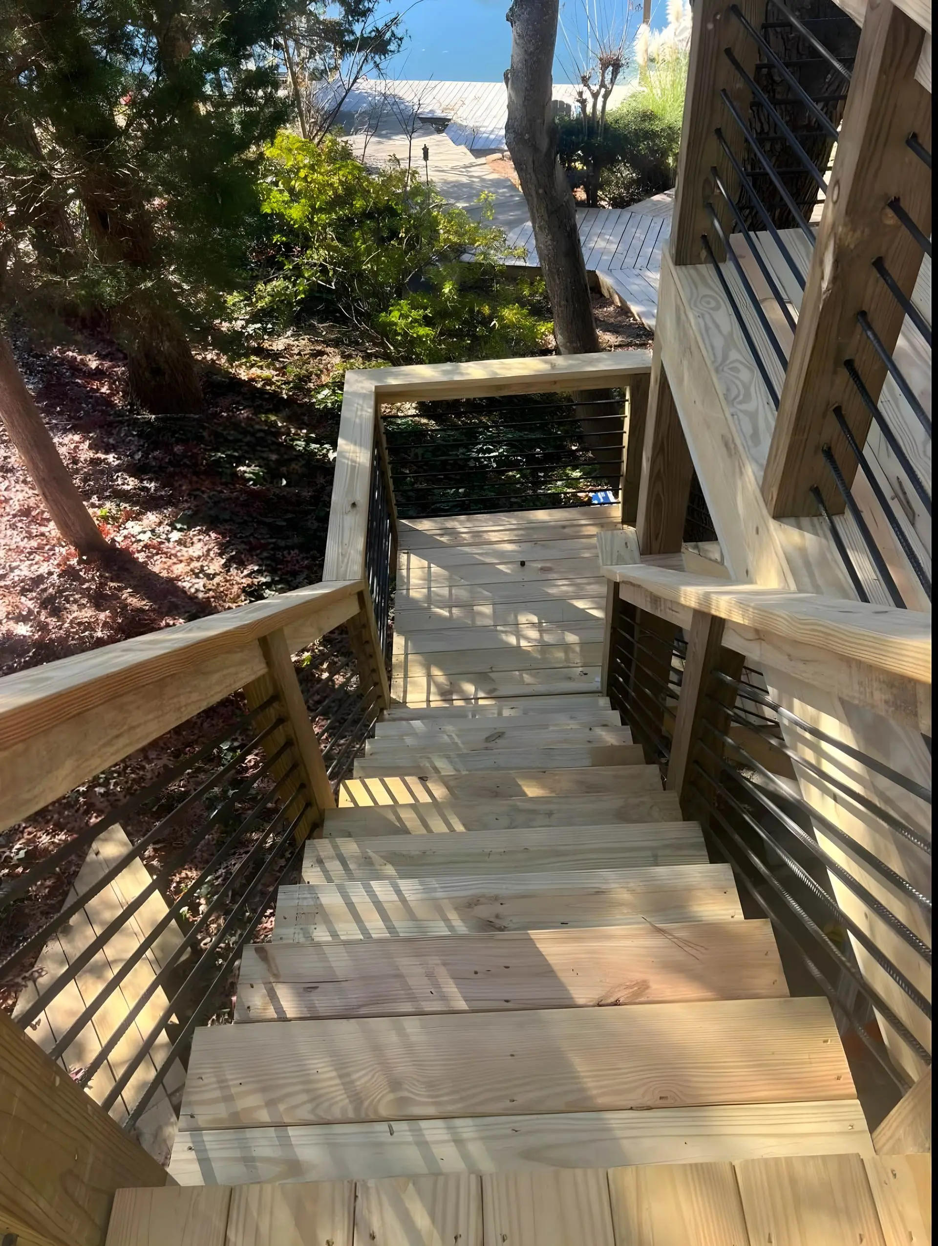 Wood stairs with cable rail down to a lake dock